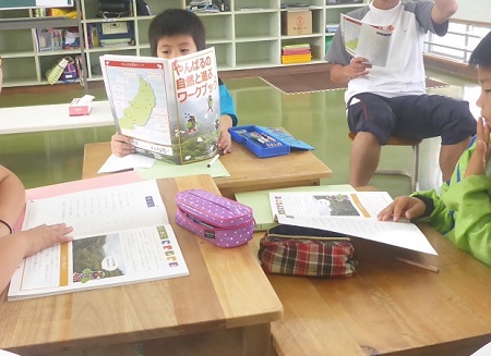 一緒にテキストを読み進め、課題に取り組む児童たち（2017年4月26日撮影）。