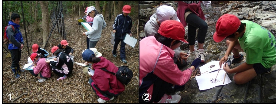 西部地域で植生保護柵の説明を熱心にメモする児童と糞をルーペで観察する児童