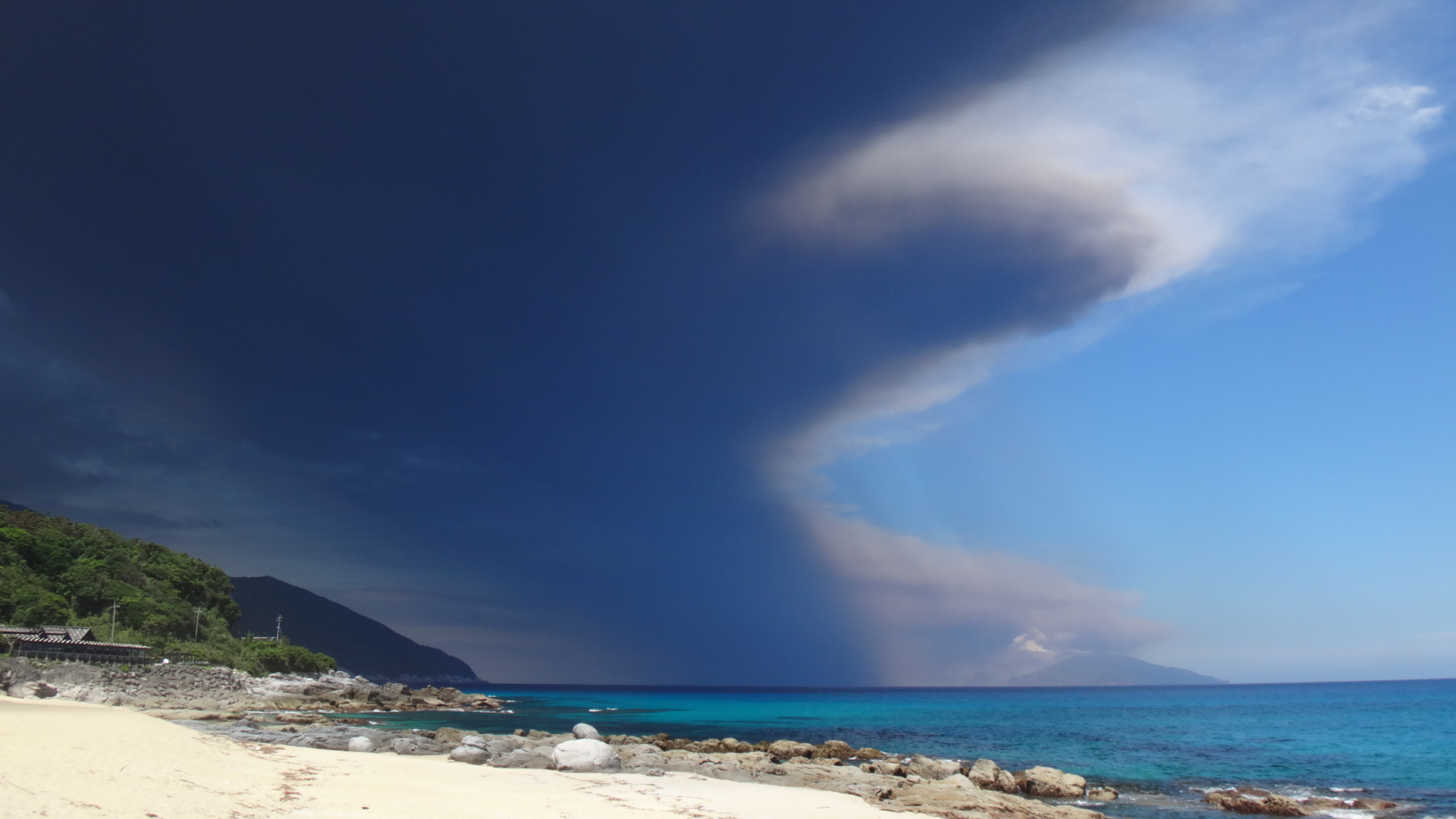 屋久島の永田浜から撮影した屋久島上空にせまる噴煙