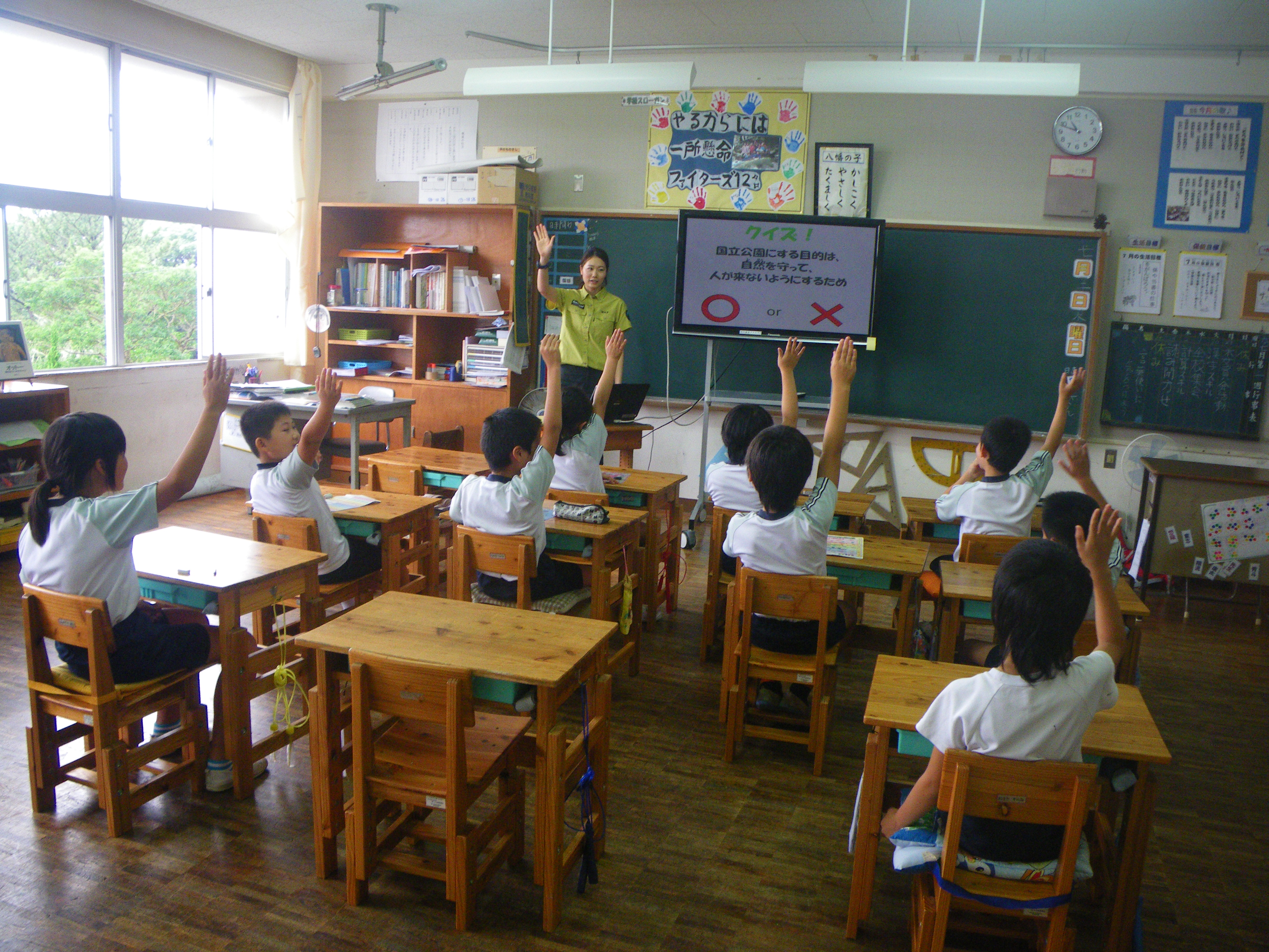 教室で○×クイズに答える児童の様子