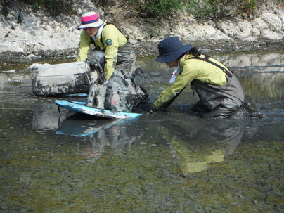 ボディボードを使って泥干潟のゴミを拾う作業の様子（2015年10月撮影）